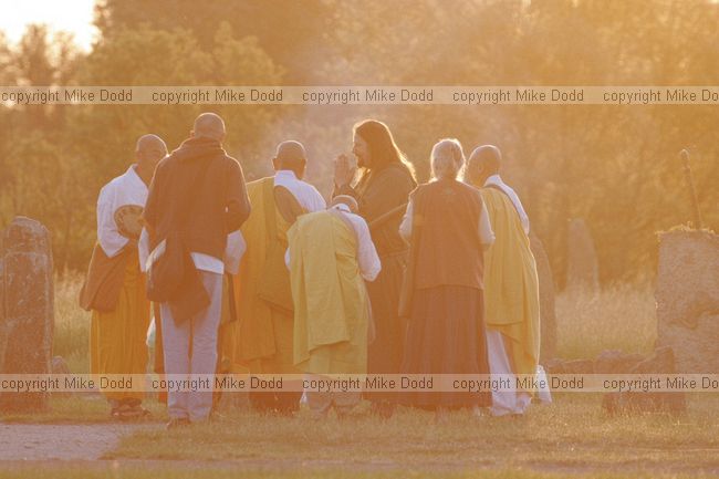 Nick the priest greets Buddhist monks moments after sunrise summer solstice ceremonies at Willan stone circle Milton Keynes